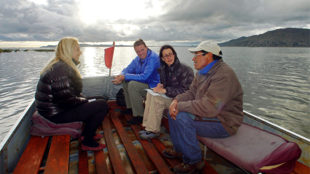 Verschiedene Welten: Europäische Touristen im Gespräch mit dem einheimischen Bootsführer auf dem Titicacasee in Peru. | © Claus Possberg/Latinphoto.org
