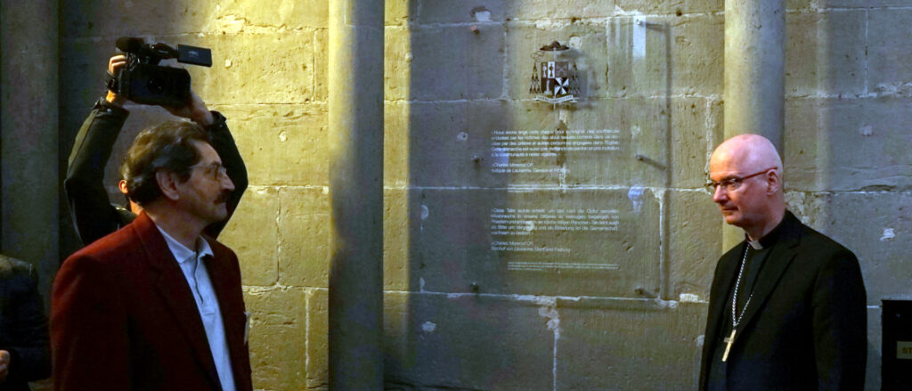 Bischof Charles Morerod (rechts) mit Jacques Nuoffer von der Opferhilfsvereinigung «Groupe Sapec» vor der Gedenktafel in der Kathedrale Freiburg. | © Georges Scherrer, kath.ch