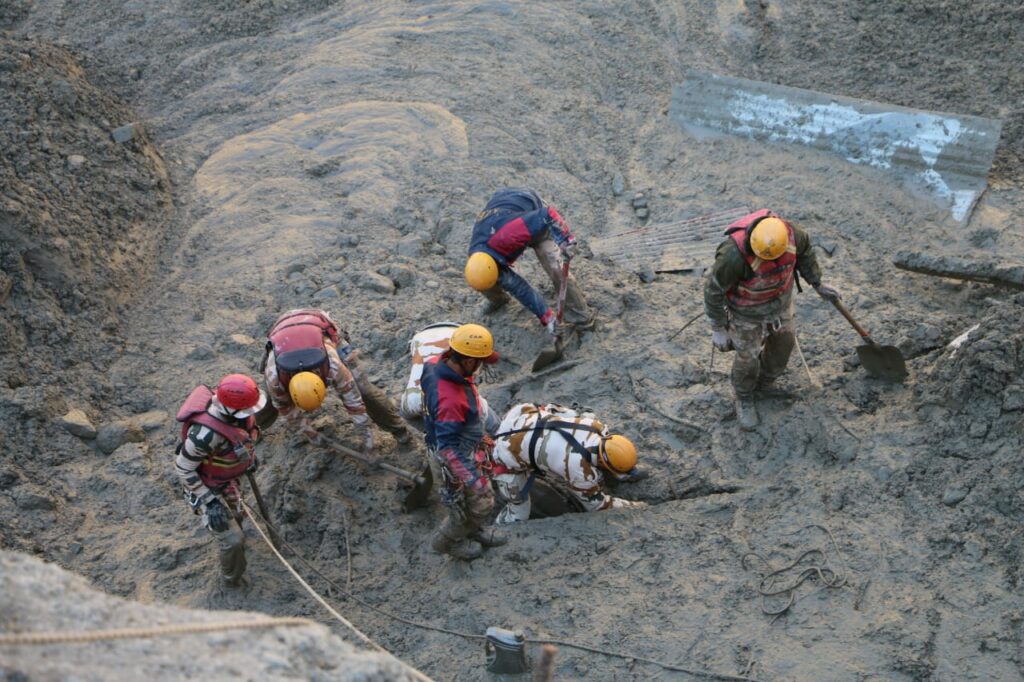 Katastropheneinsatz nach einer Gerölllawine im indischen Himalayagebiet. Eine Gruppe von Helfern sucht nach Verschütteten. | © wikimedia/Press Information Bureau India