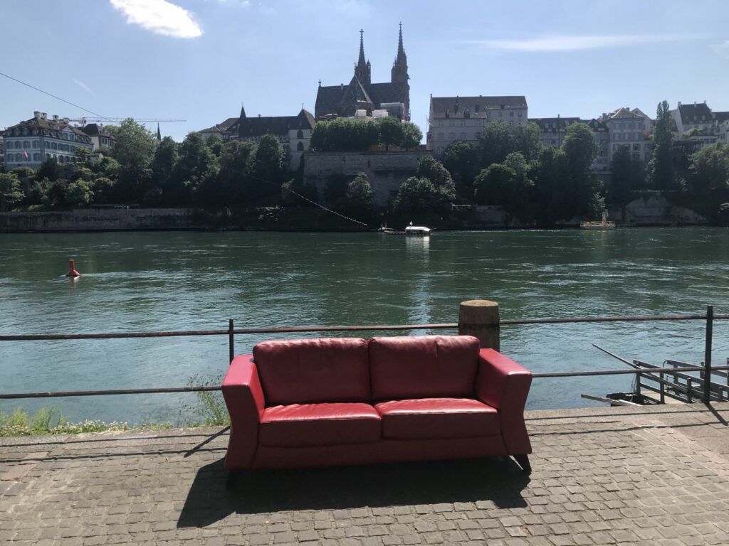 Das Rote Sofa der RKK Basel-Stadt befindet sich je nach Wetter ein- bis zweimal pro Woche für jeweils zwei Stunden am Kleinbasler Rheinufer – wenige Meter von der Anlegestelle der Münsterfähre entfernt. | © zVg
