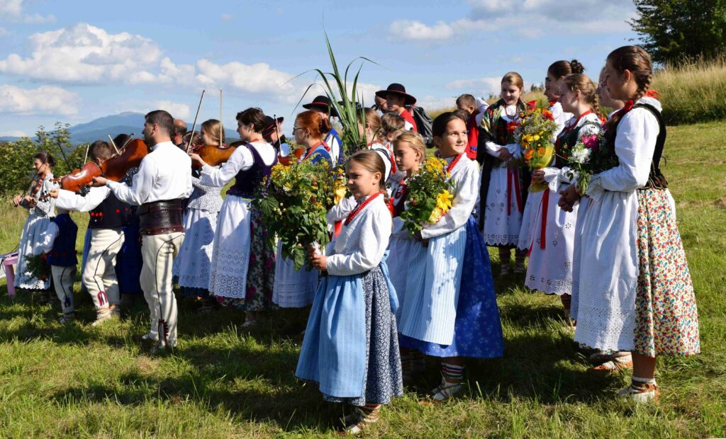 Seit Jahrhunderten ist das Fest der Aufnahme Mariens in den Himmel (volkstümlich Mariä Himmelfahrt genannt) mit der Weihe von Blumen und Kräutern verbunden. Bild: Folkloregruppe mit Sträussen an einem 15. August im Ort Juszczyna in den Saybuscher Beskiden (Beskid Żywiecki), einem Gebirgszug der Karpaten im polnischen Schlesien nahe dem Dreiländereck mit der Slowakei und Tschechien. | © wikimedia/Wpedzich