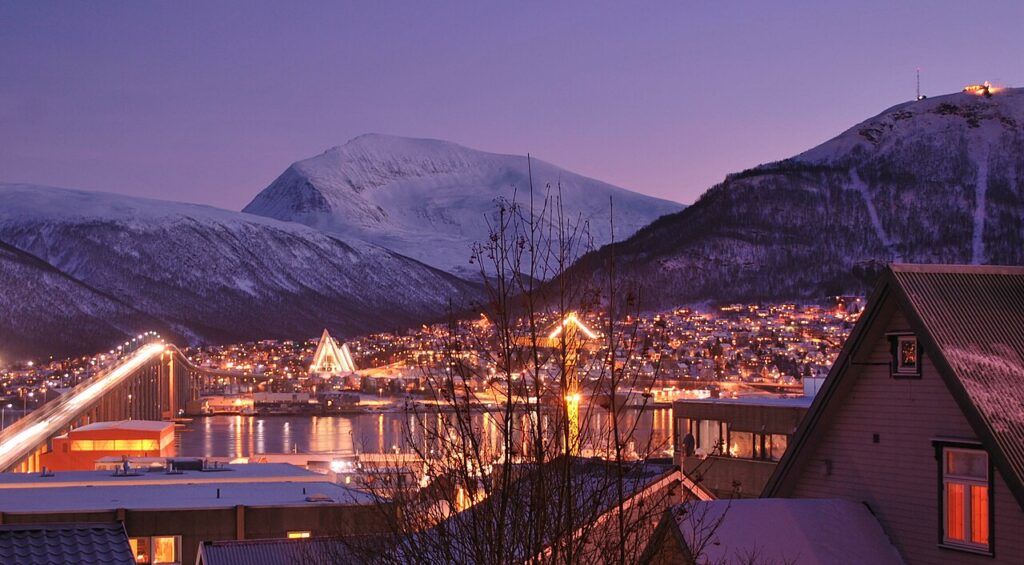 In Tromsø in Nordnorwegen (Bild) wird die Sonne erst am 15. Januar 2024 wieder aufgehen. Dort, wo die Sonne nicht allzu weit unter dem Horizont steht, ist es allerdings nicht ganz dunkel. Licht bringt auch Freundlichkeit. Im nordschwedischen Luleå hat die Stadtverwaltung im Herbst mit einer Hej-Kampagne die Menschen zum freundlichen Grüssen aufgerufen. | © wikimedia commons/Osopolar
