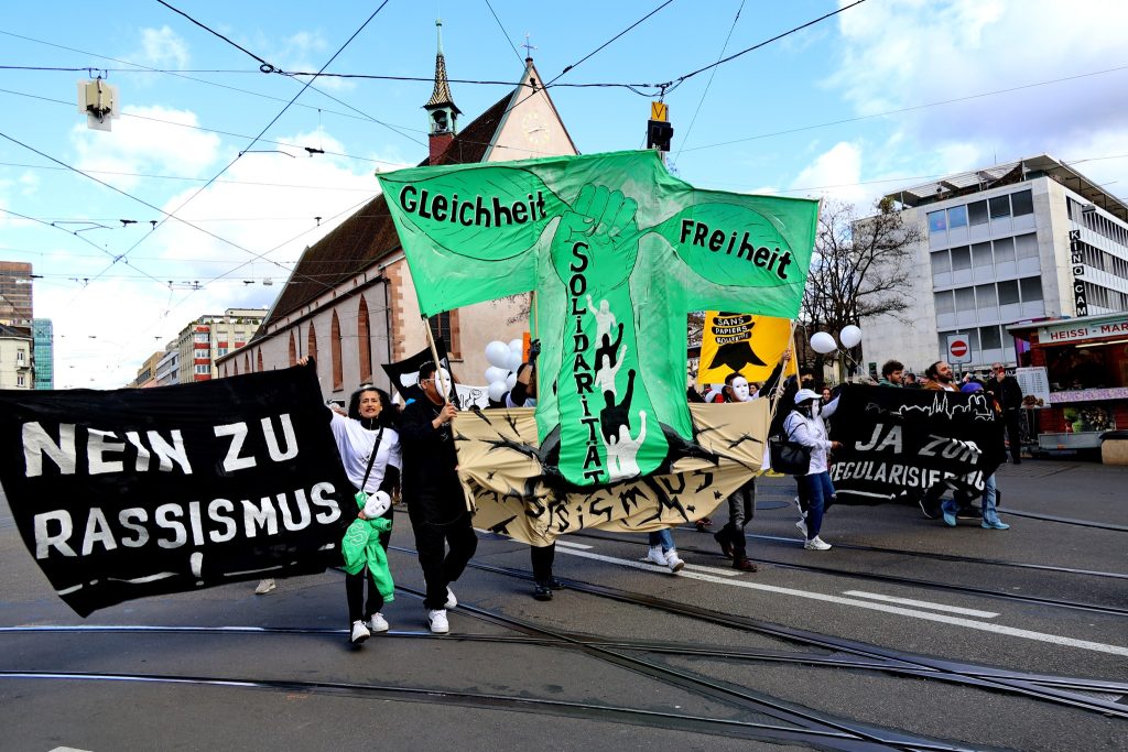 Am 21. März ist der Tag gegen Rassismus. Bereits am 16. März gingen Hunderte Menschen in Basel auf die Strasse, um gegen Rassismus und für die Regularisierung von Sans-Papiers, also Menschen ohne Papiere, zu demonstrieren. Mit Sprechchören, Tänzen und Transparenten machten sie auf ihre Anliegen aufmerksam. | © František Matouš