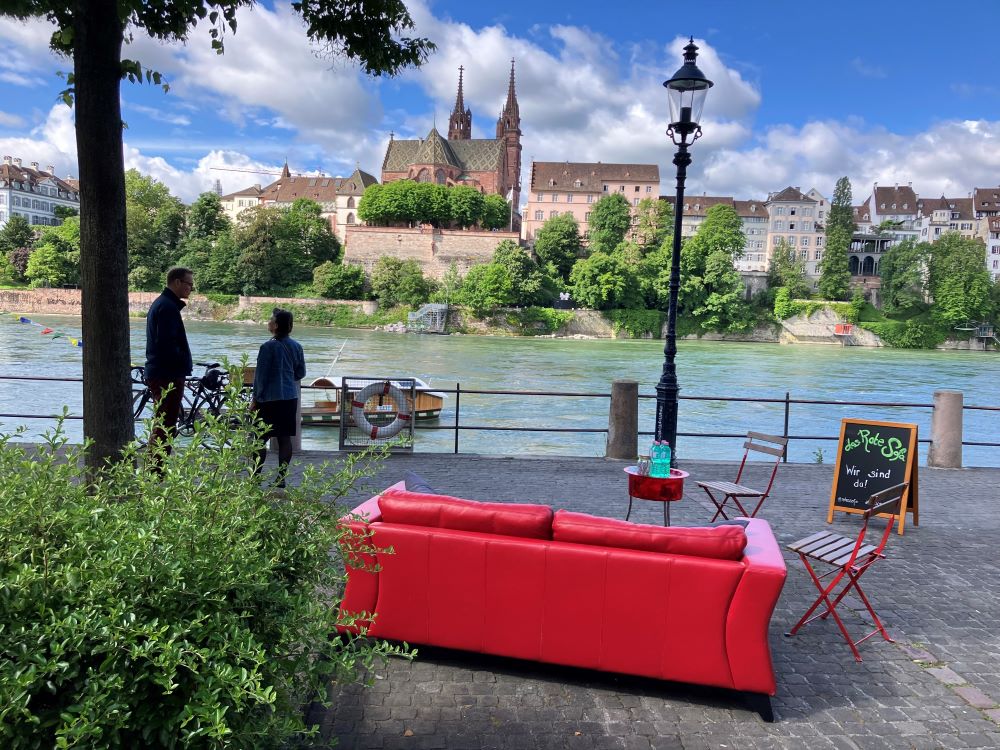 Bis zum 19. September 2024 laden Mitarbeitende der Römisch-Katholischen Kirche Basel-Stadt mit dem «Roten Sofa» etwa zweimal wöchentlich am Kleinbasler Rheinufer unterhalb der Wettsteinbrücke zum Gespräch ein. «Das Rote Sofa bietet einen Raum, in dem alles erzählt werden kann, ohne Wertung. Das ist eine typische Aufgabe von Seelsorge, einfach exponierter als sonst und im öffentlichen Raum», so Sarah Biotti, Leiterin Spezialseelsorge. | © Römisch-katholische Kirche Basel-Stadt